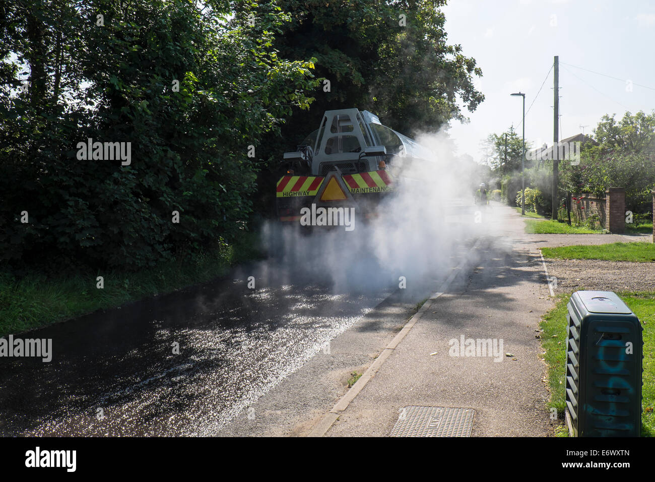 Road tar tanker spreading hot tar to take chippings Fen Road Milton Stock Photo