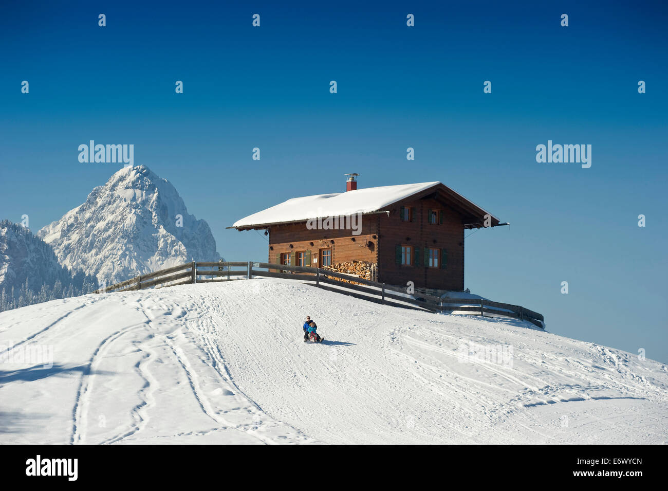 People sledging at Eckbauer, Alpspitze in the background, Garmisch-Partenkirchen, Bavaria, Germany Stock Photo