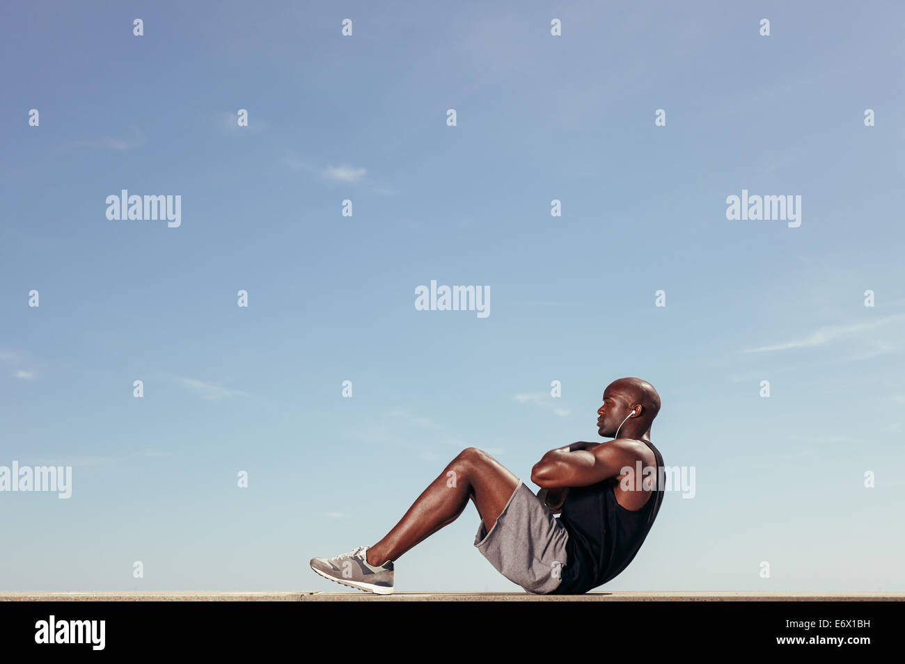 Fit man doing calisthenics workout crunches sit ups on parallel