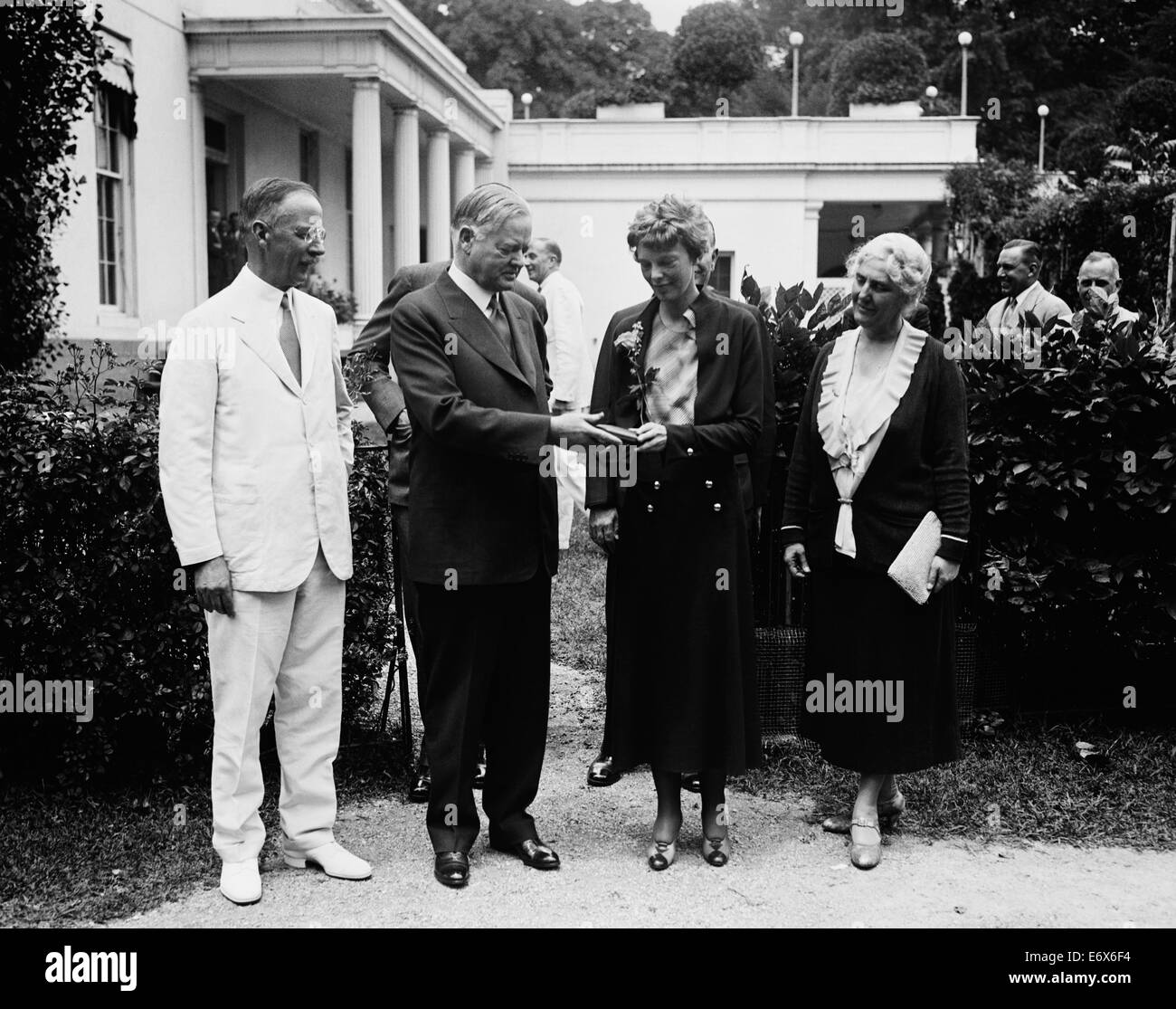 Vintage photo of American aviation pioneer and author Amelia Earhart (1897 – declared dead 1939) – Earhart and her navigator Fred Noonan famously vanished in 1937 while she was trying to become the first female to complete a circumnavigational flight of the globe. Earhart is pictured at The White House in June 1932 where President Herbert Hoover presented her with a National Geographic Society gold medal in recognition of her non-stop solo flight across the Atlantic. Stock Photo