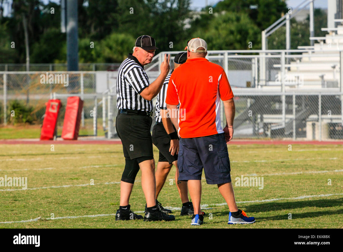 The referee at a football game gives a V sign to a team coach Stock