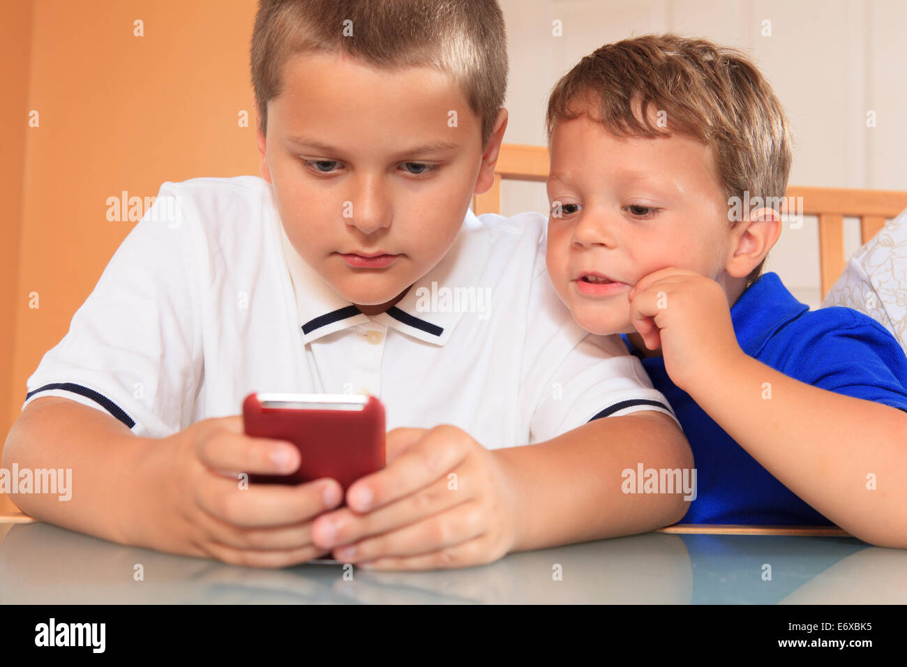 Young boys playing with their cell phone Stock Photo