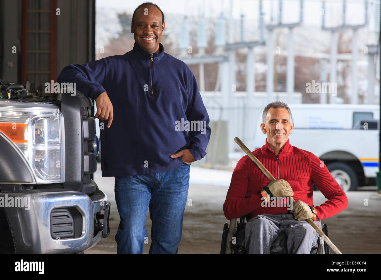 Maintenance technicians cleaning in utility truck garage at Electric Power Plant Stock Photo