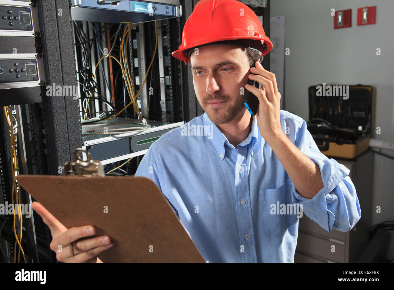 Network engineer on phone performing trouble shooting Stock Photo