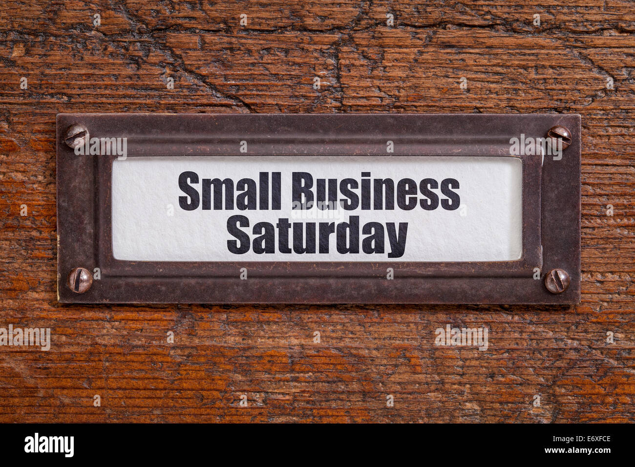 Small Business Saturday - file cabinet label, bronze holder against grunge and scratched wood Stock Photo