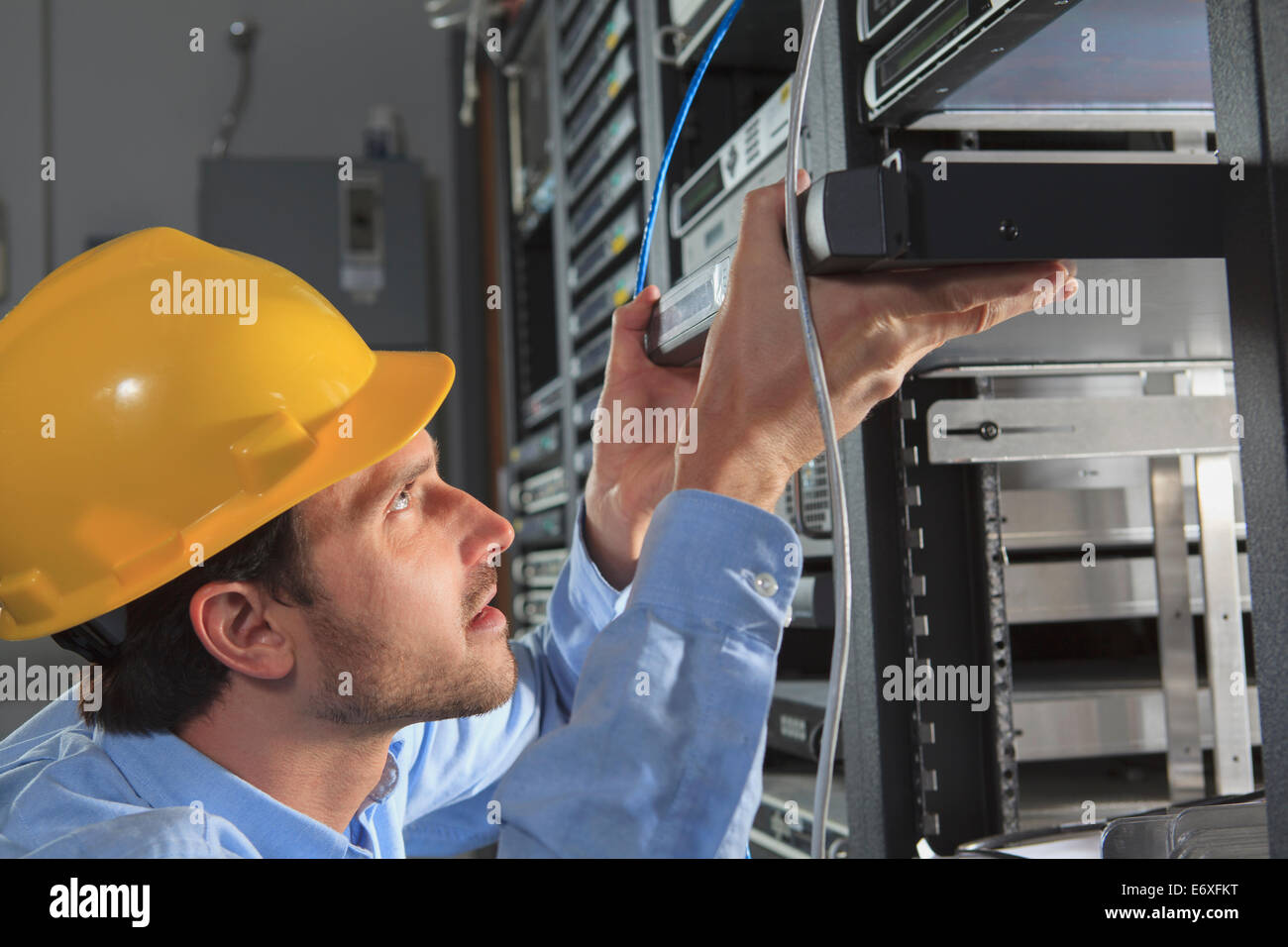 Network engineer installing cable equipment in rack Stock Photo Alamy