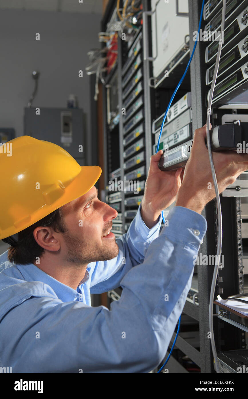 Network engineer installing cable equipment in rack Stock Photo Alamy