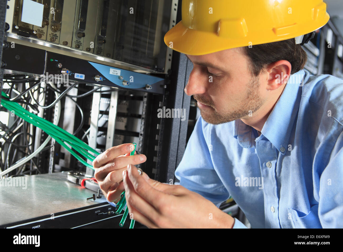 Network engineer examining cable for termination Stock Photo