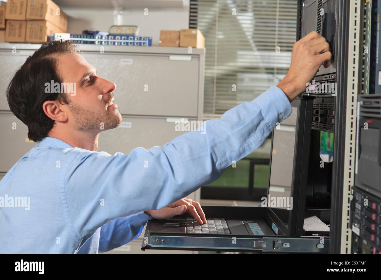 Network engineer working on computer in data center Stock Photo