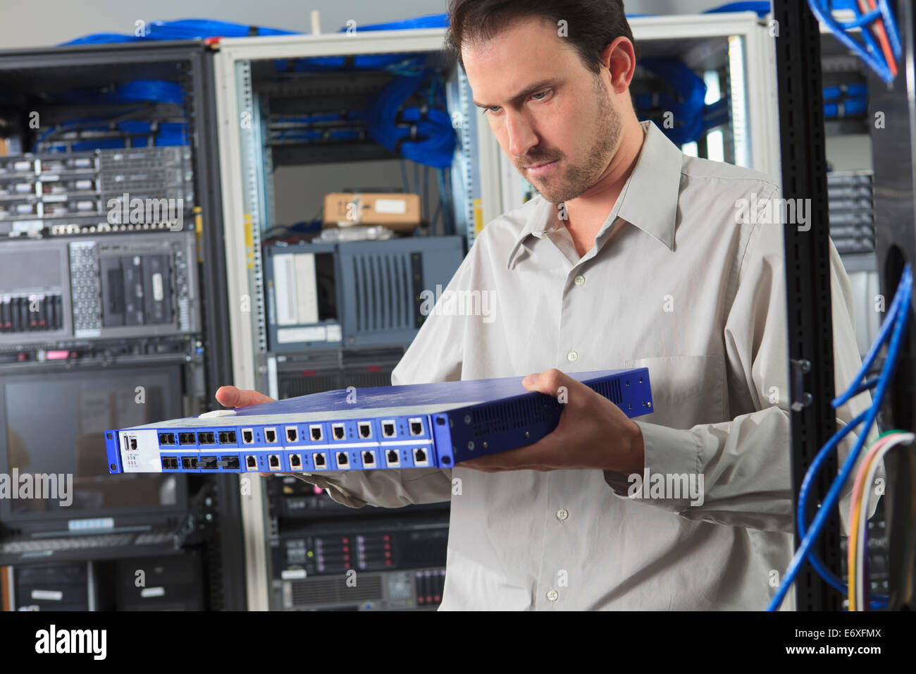 Network engineer examining switch in data center Stock Photo