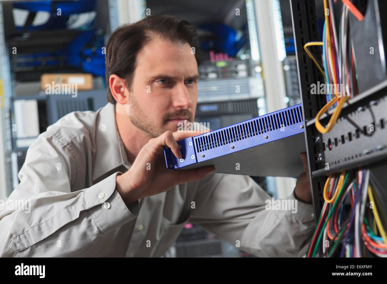 Network engineer installing switch in data center Stock Photo