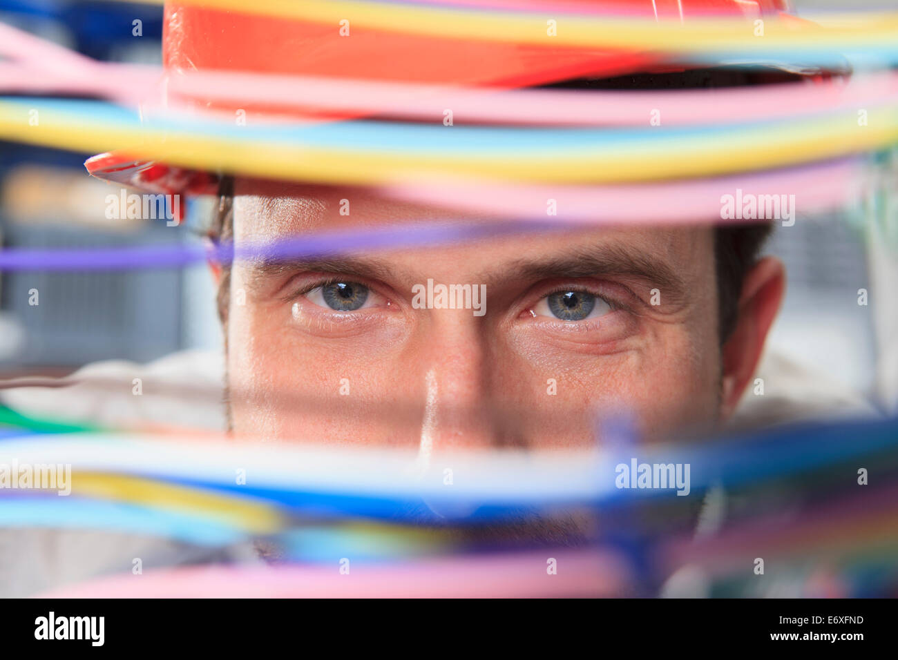 Network engineer examining multi color fiber and copper cables in data center Stock Photo