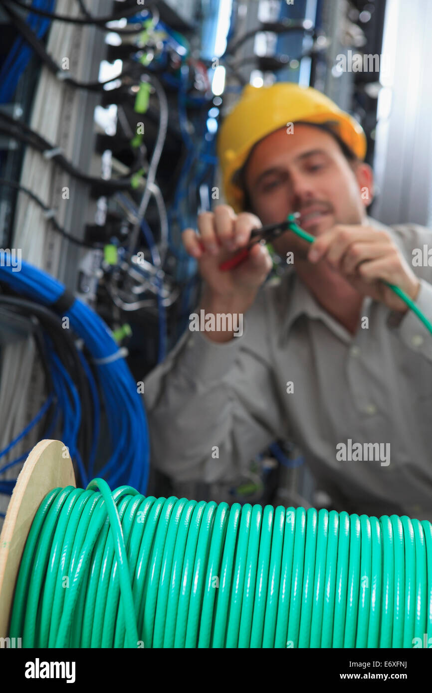 Network engineer cutting cable termination in network data center Stock Photo