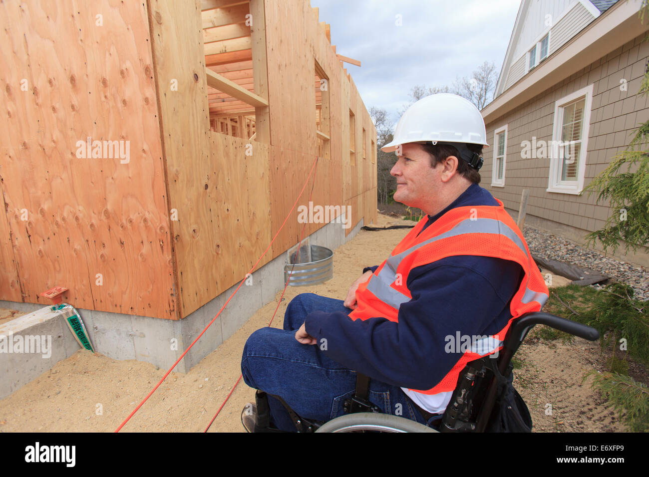 Construction engineer with spinal cord injury inspecting new house construction Stock Photo