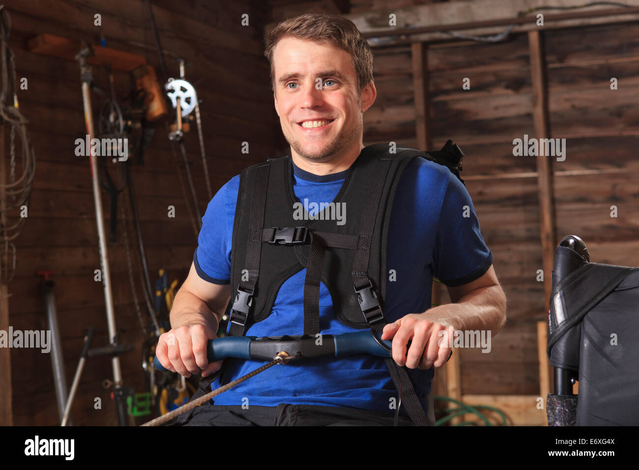Man with spinal cord injury using his rowing machine Stock Photo