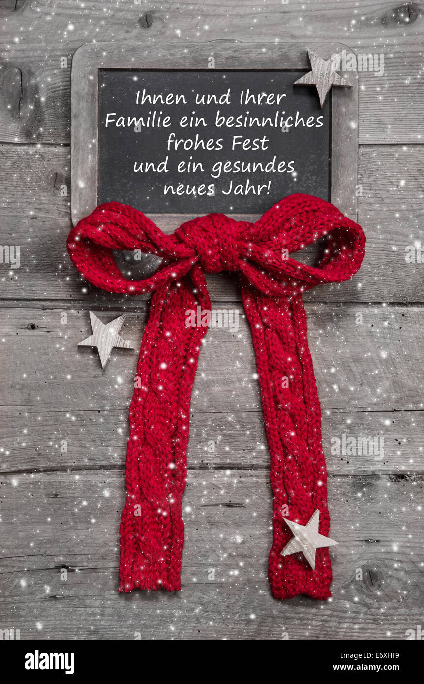 Christmas greeting card with german text in old country style on wooden grey background. Stock Photo