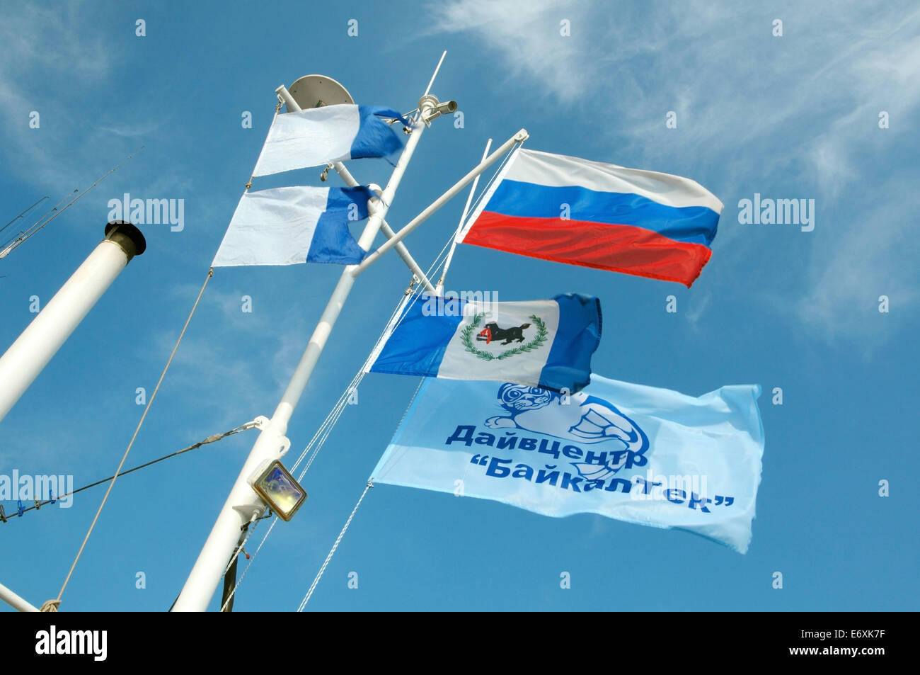 Flags on the mast of a diving boat on the background of sky Stock Photo