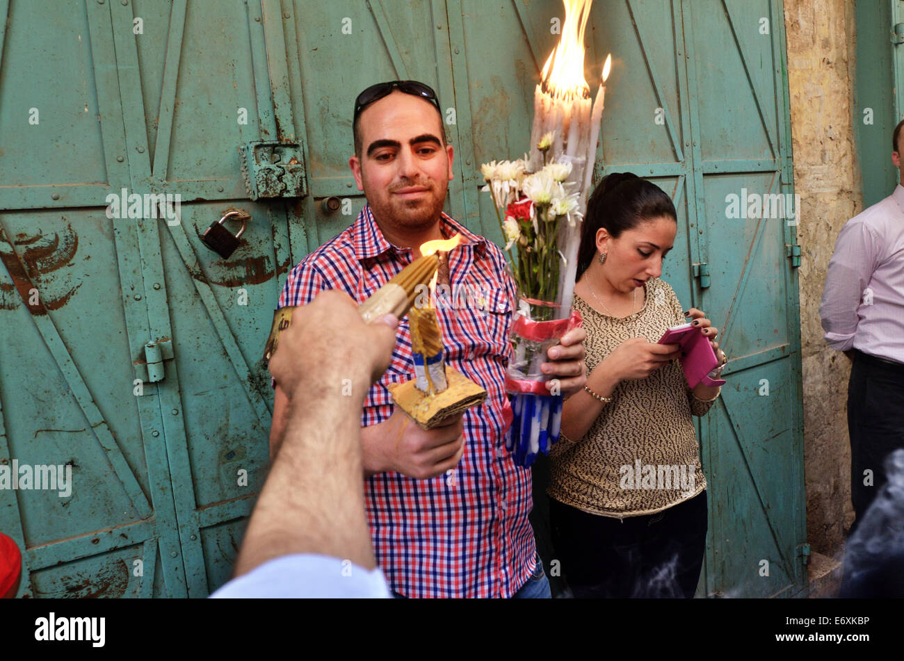 Man shares fire from candles to candles during Holy Fire ceremony in Jerusalem, Israel Stock Photo