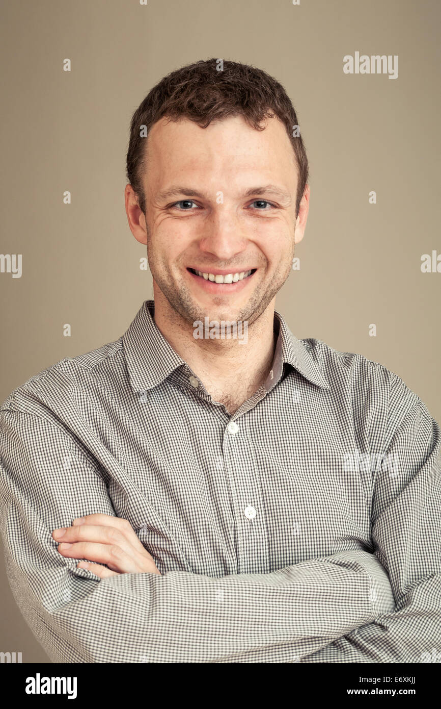 Young Caucasian man smiles, casual studio portrait, with toned effect Stock Photo
