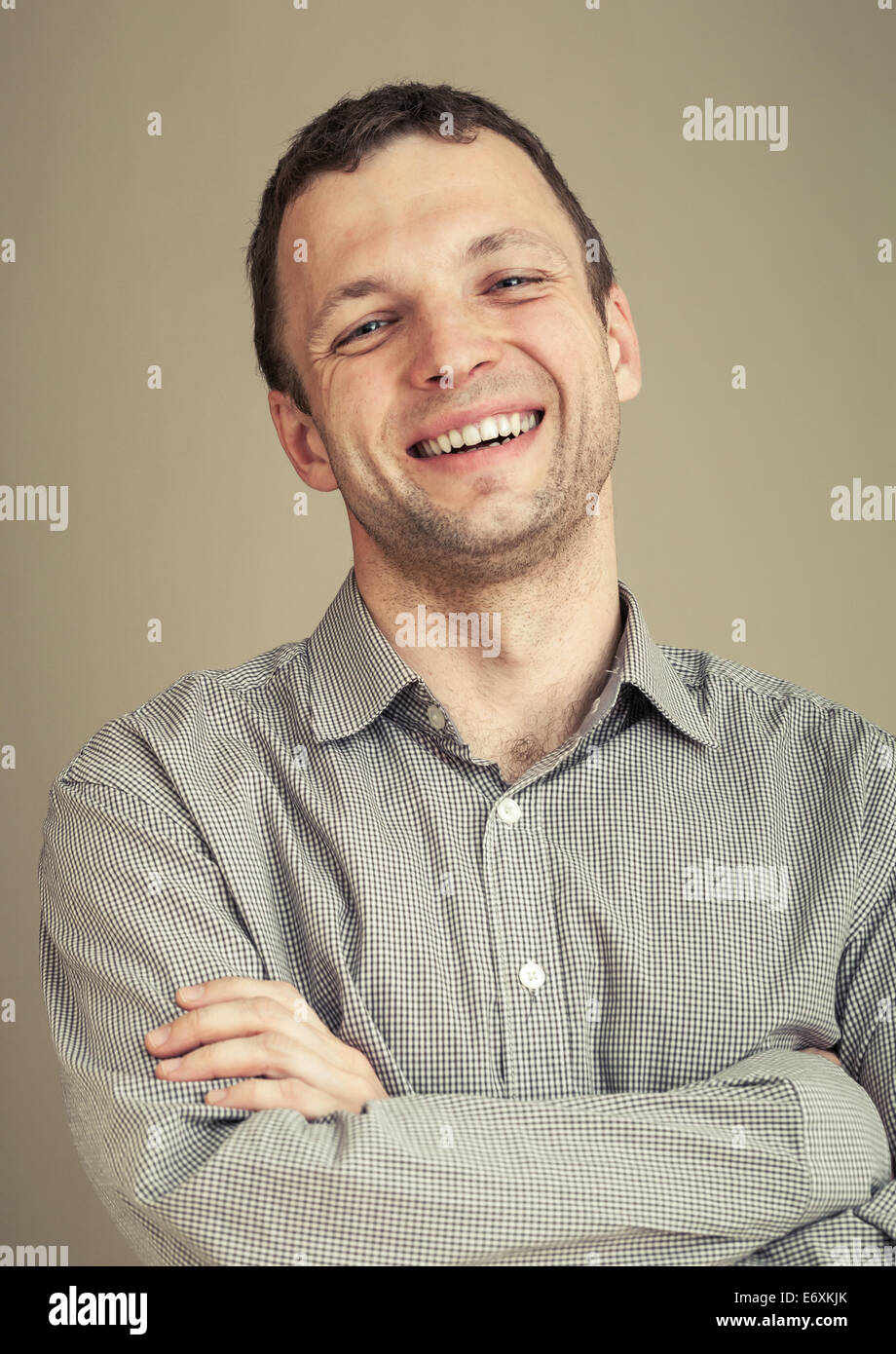 Young Caucasian man laughs, casual studio portrait, with toned effect Stock Photo