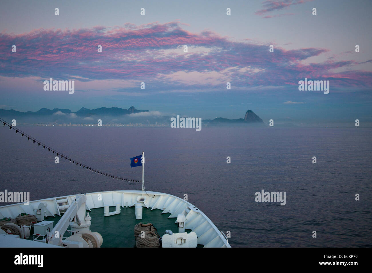 Bow of cruise ship MS Deutschland (Reederei Peter Deilmann) approaching Rio at dawn, with Pao de Acucar (Sugar Loaf) mountain in Stock Photo