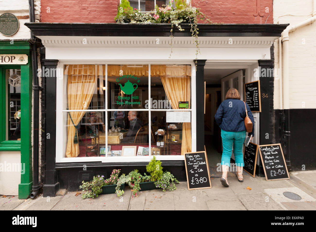 A woman entering Compton's Tea Rooms, one of many tea rooms on Steep Hill, Lincoln, Lincolnshire UK Stock Photo
