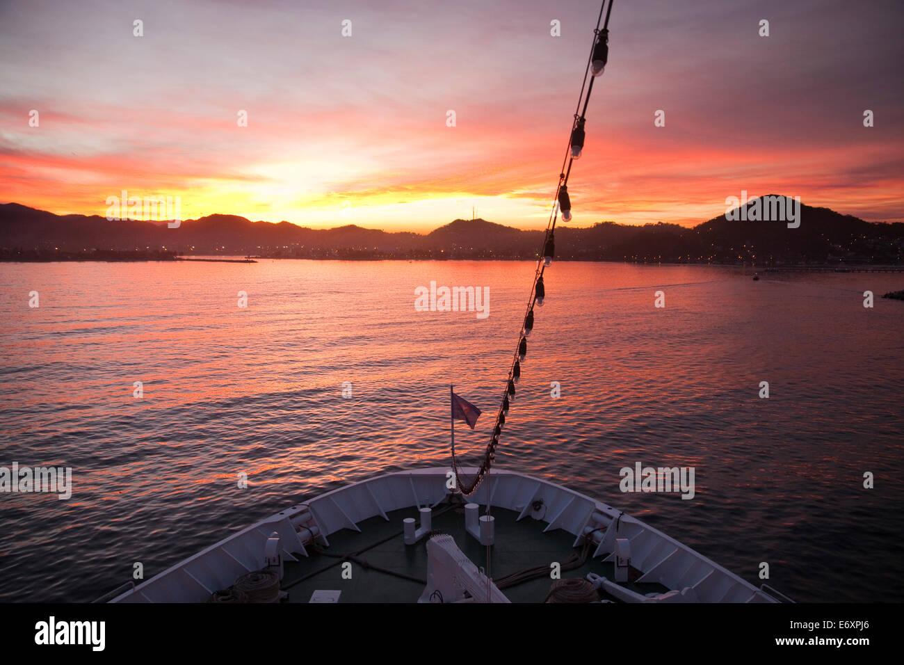 Bow of cruise ship MS Deutschland (Reederei Peter Deilmann) and coastline at sunrise, Manzanillo, Colima, Mexico Stock Photo