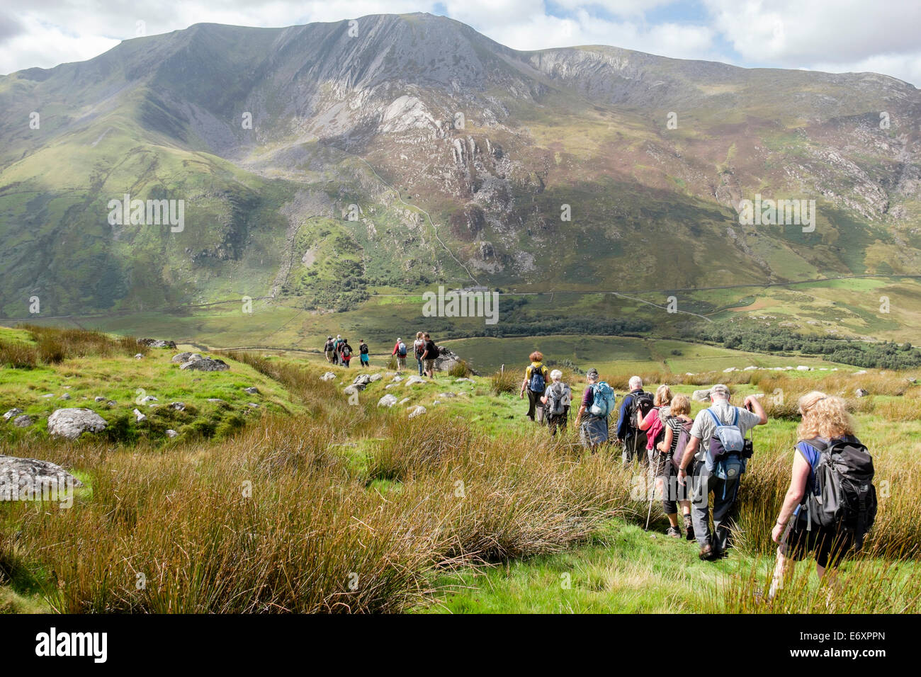 Ramblers group hiking above Nant Ffrancon valley with Carnedd Y Filiast and Mynydd Perfed beyond in mountains of Snowdonia National Park Wales UK Stock Photo