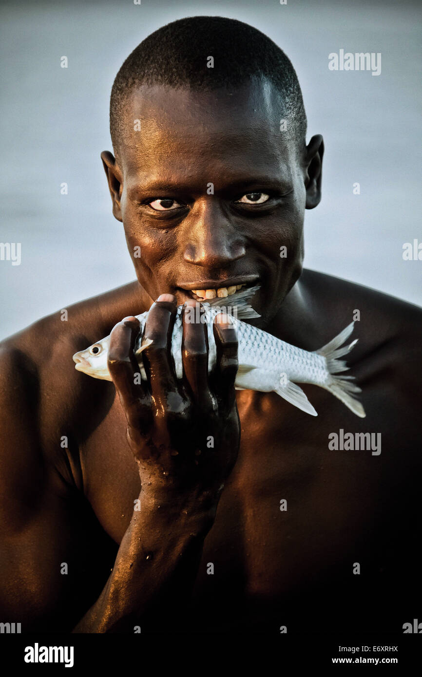 A fisherman from the Njemps tribe holding a fish, Lake Baringo, Kenya, Africa Stock Photo