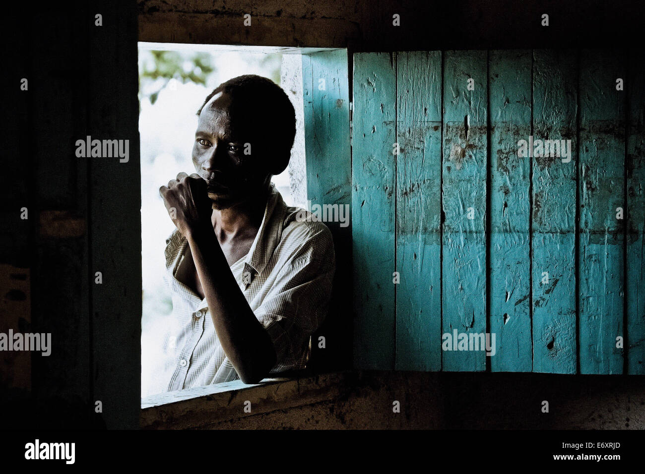 Man standing at the window of his hut, Uganda, Africa Stock Photo