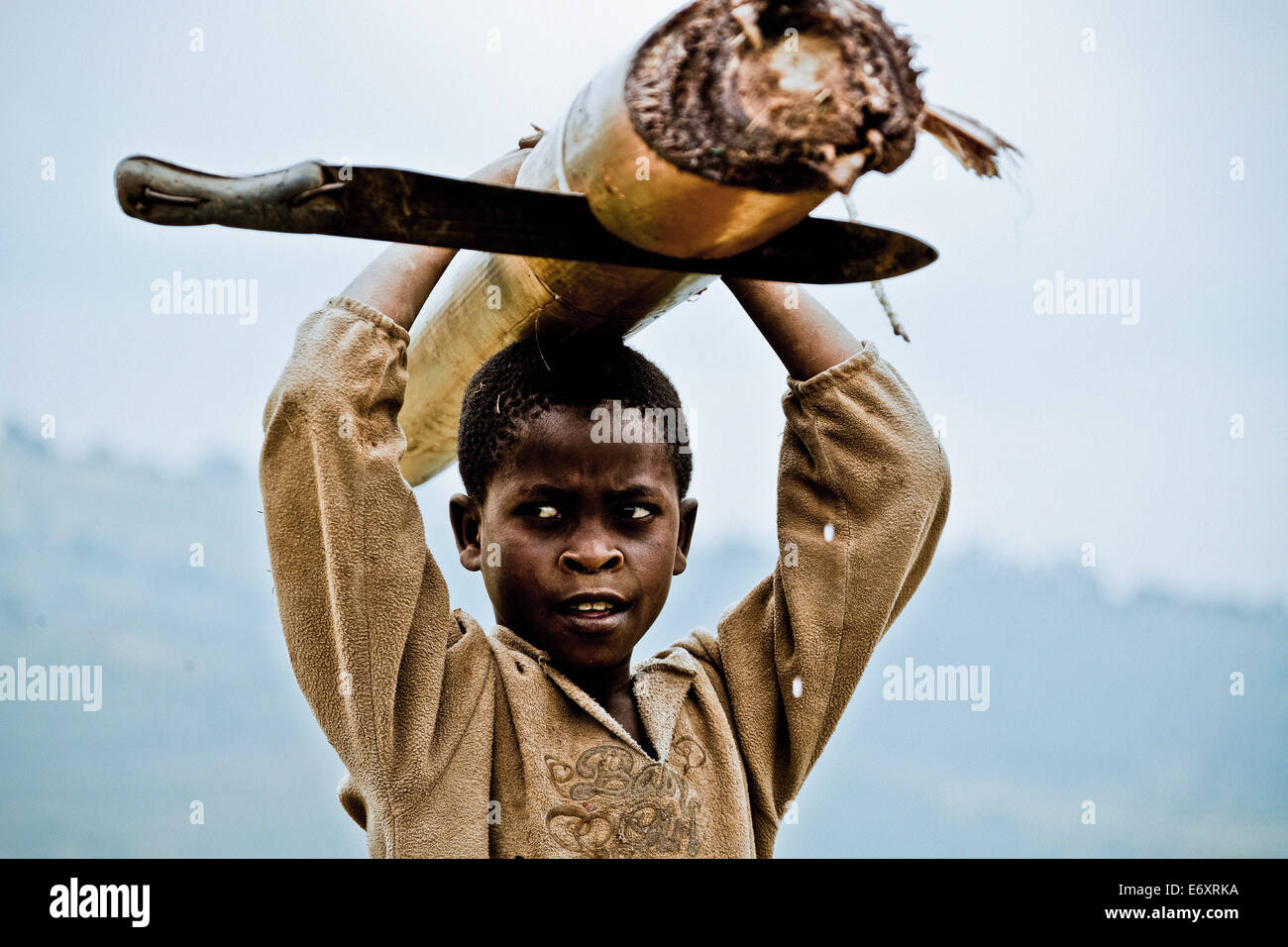 Boy carrying a banana tree and machete, Lake Buyonyi, Uganda, Africa Stock Photo