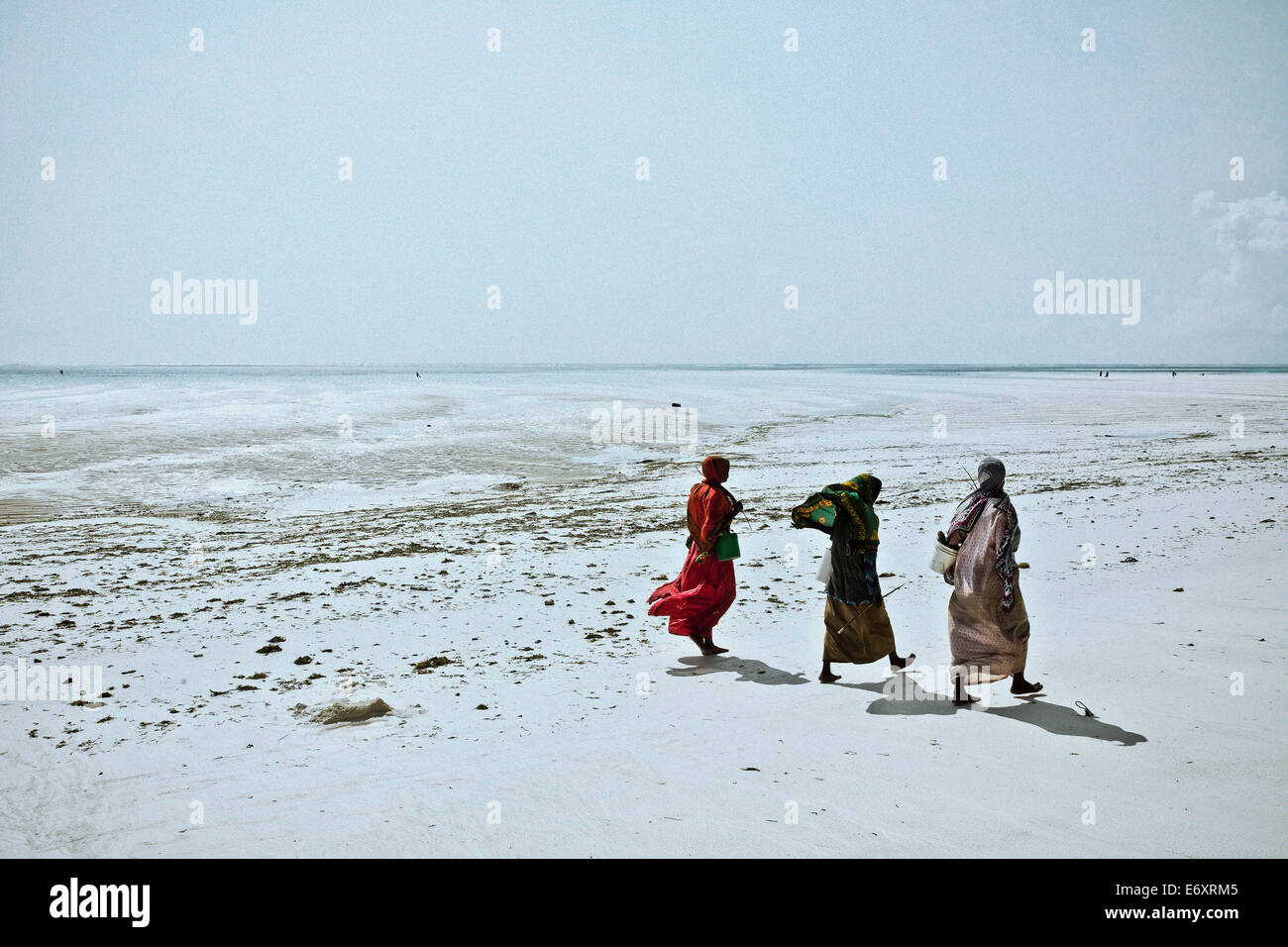Women walking along the beach, Zanzibar, Tanzania, Africa Stock Photo