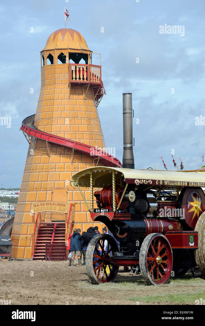 A showman's steam traction engine stands by a traditional wooded helter skelter at the Great Dorset Steam Fair 2014 Stock Photo