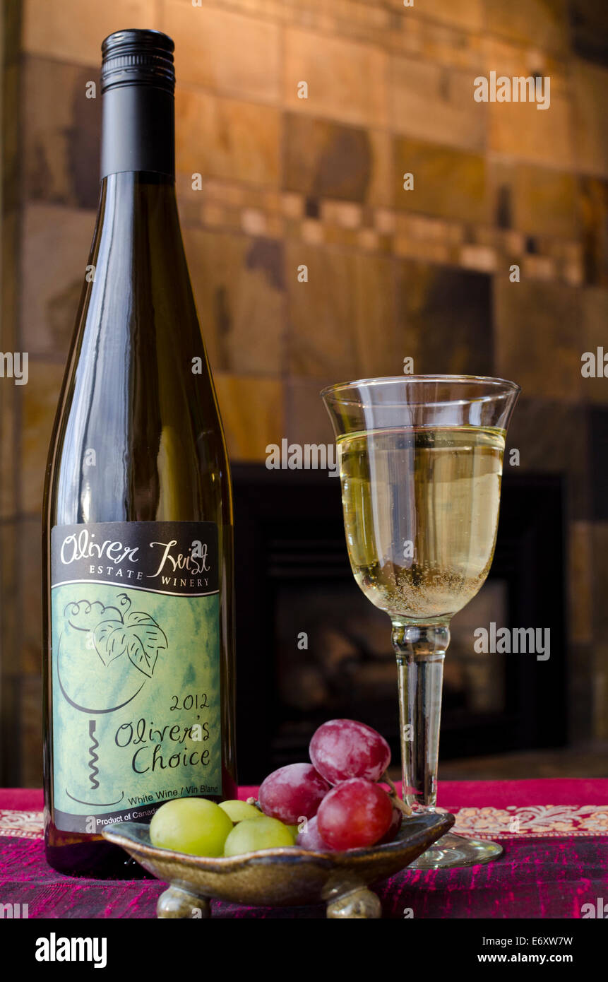 Glass of white Canadian wine with a bottle of Oliver Twist wine from