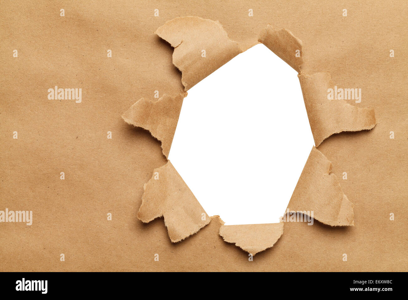 Large Hole in Brown Paper With White Background. Stock Photo