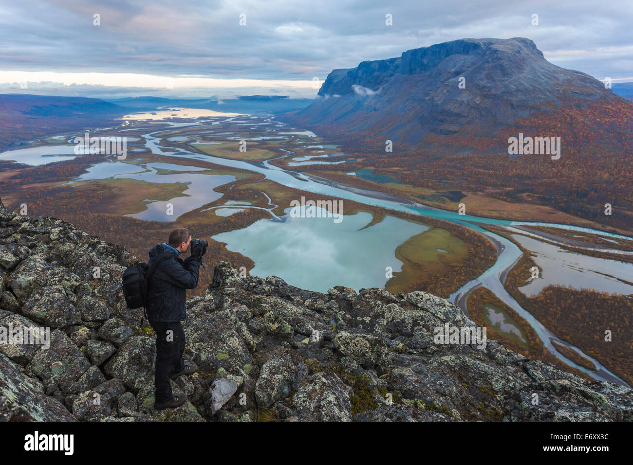 Photographer taking picture on the view from mount Namatj over  the Laitaure delta in Sarek national park in sweden, swedish lap Stock Photo
