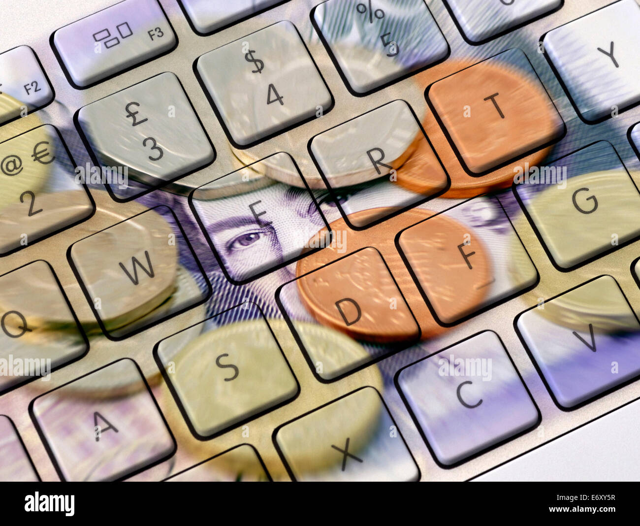 Closeup of computer keyboard overlaid with photo of UK money Stock Photo