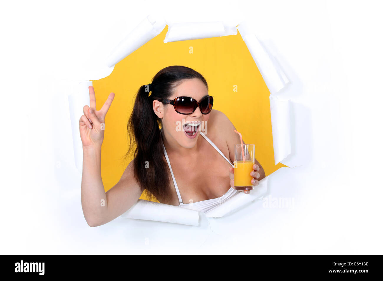 Woman coming out of hole with orange juice Stock Photo