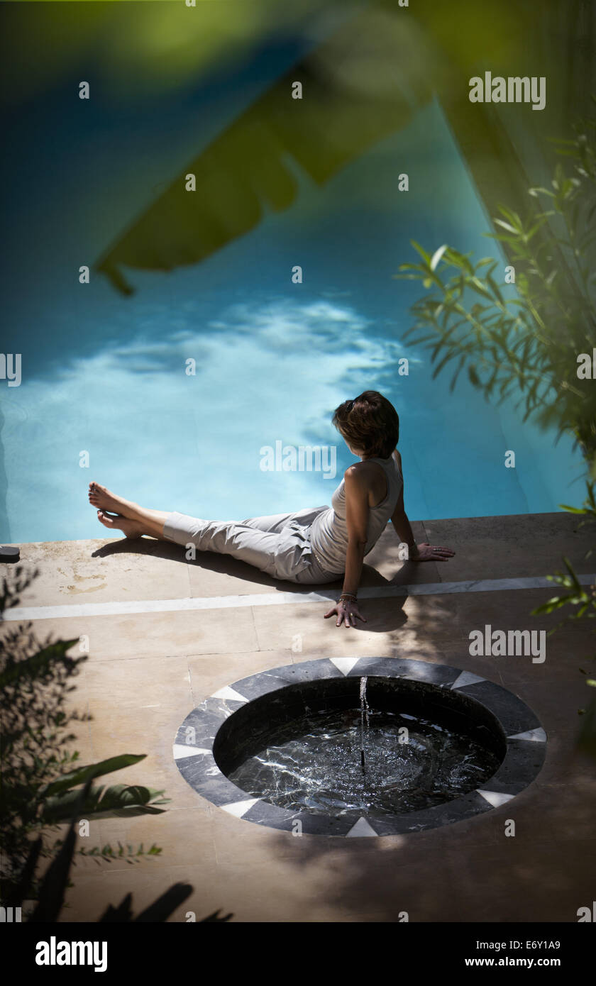 Woman relaxing by pool, El Fenn, Marrakech, Morocco Stock Photo