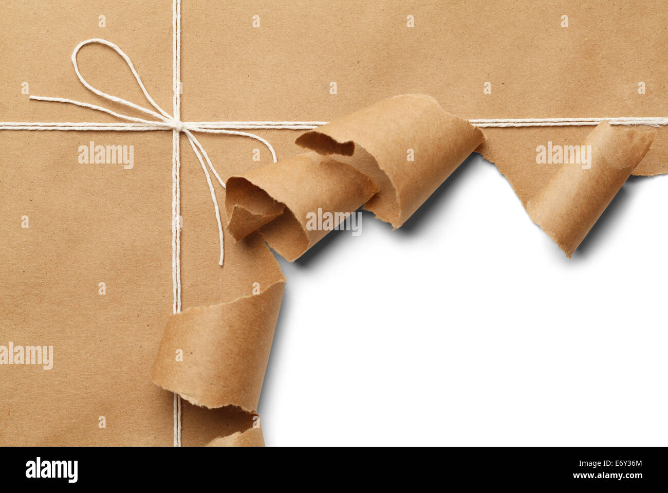 Brown Paper Parcel with Rope Torn Open on White Background. Stock Photo