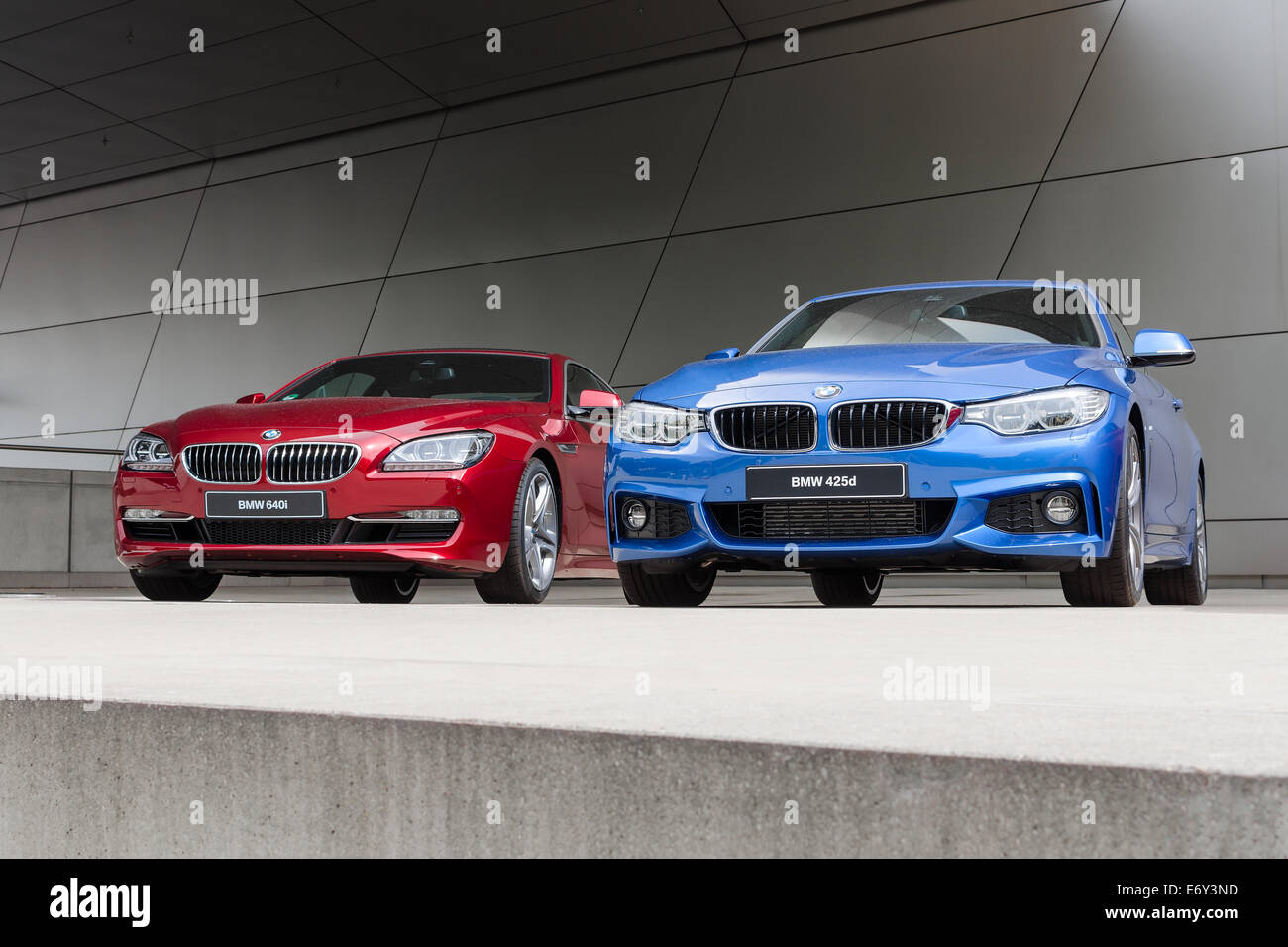 MUNICH, GERMANY - AUGUST 9, 2014: New modern models of executive business class BMW cars. Red 640i and blue 425d wet after rain Stock Photo