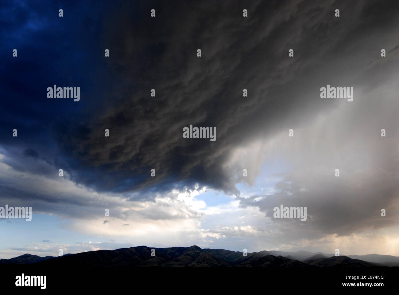 Landscape of storm clouds passing over mountain range Stock Photo