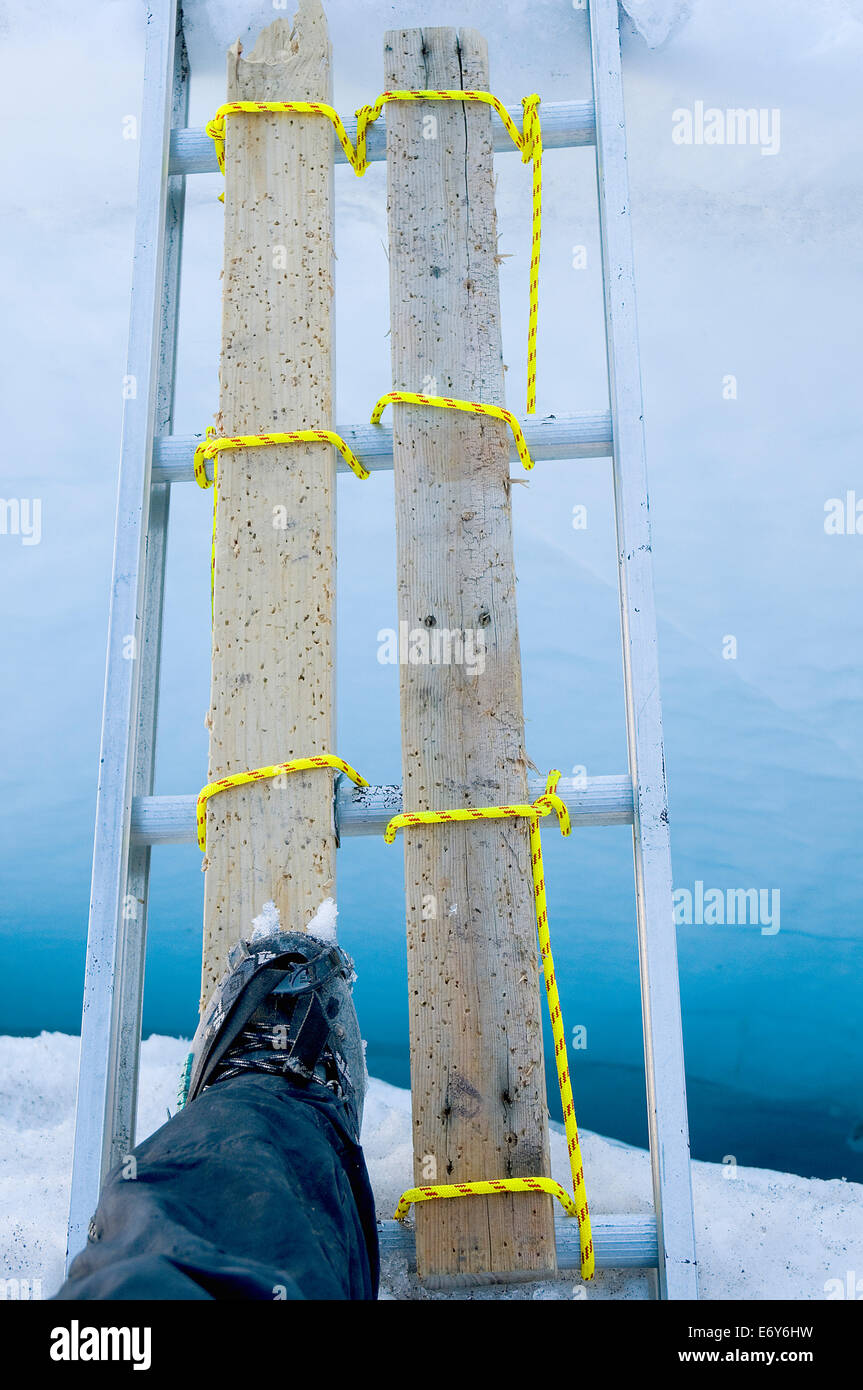 Mountain climber Peter Noebels steps lightly on a ladder which spans a crevasse on Mt  Rainer's Disappointment Cleaver route Stock Photo