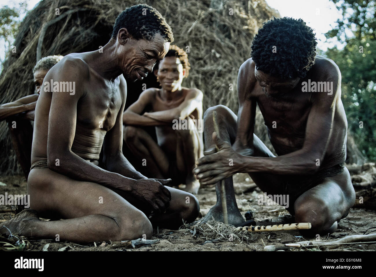 Men from the San tribe igniting a fire with two wooden sticks, Otjozondjupa region, Namibia, Africa Stock Photo