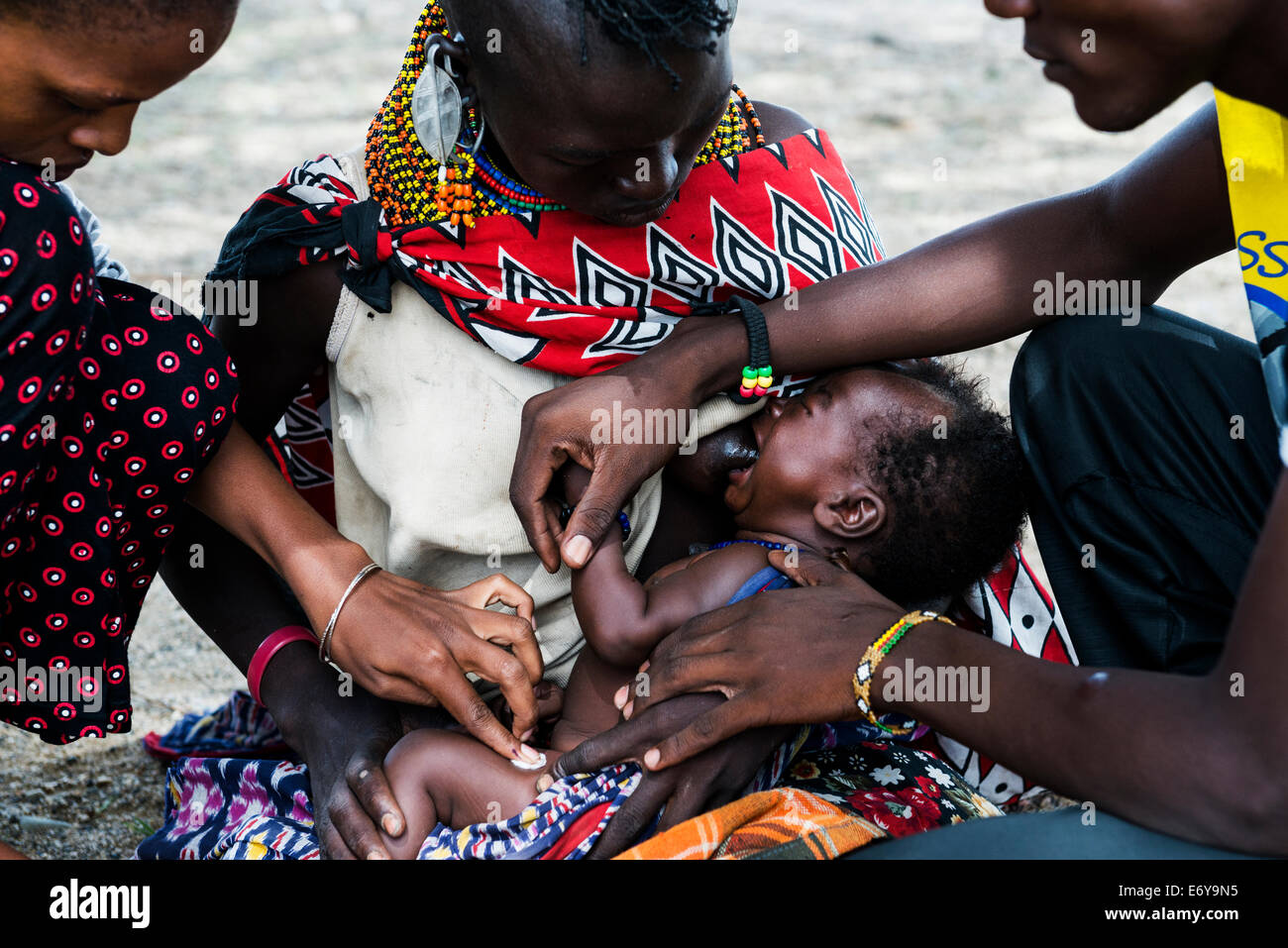 A mobile vaccination team visits a small Turkana village by the Turkana lake and vaccinates the infants and small babies. Stock Photo