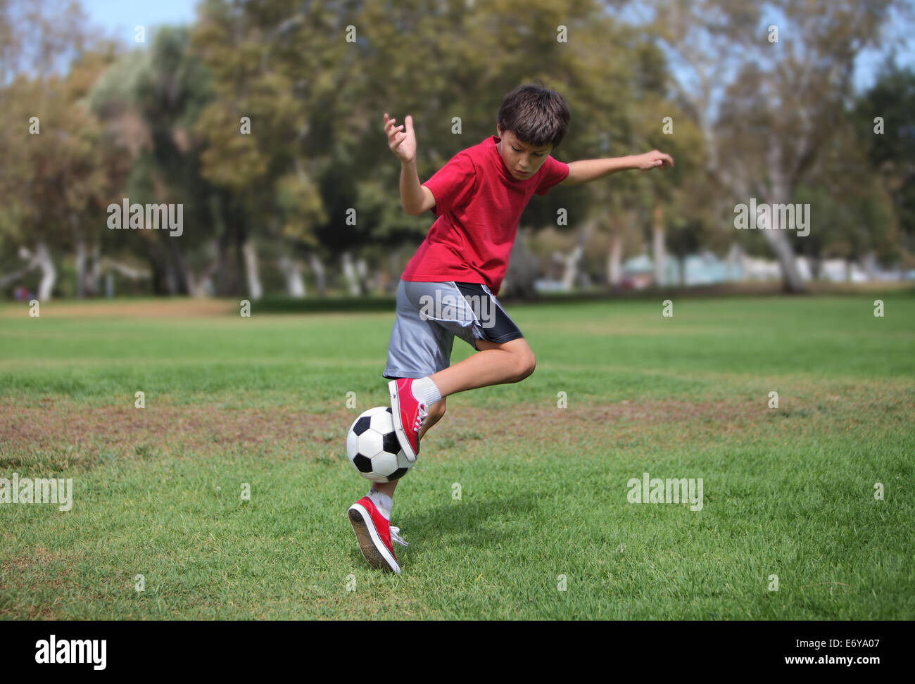 Young boy plays with a soccer ball practicing kicks authentic action Stock Photo Alamy