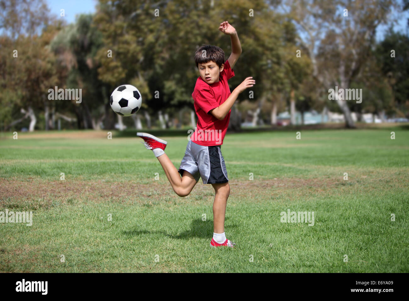 Young Boy Plays With A Soccer Ball Practicing Kicks Authentic Action Stock Photo Alamy