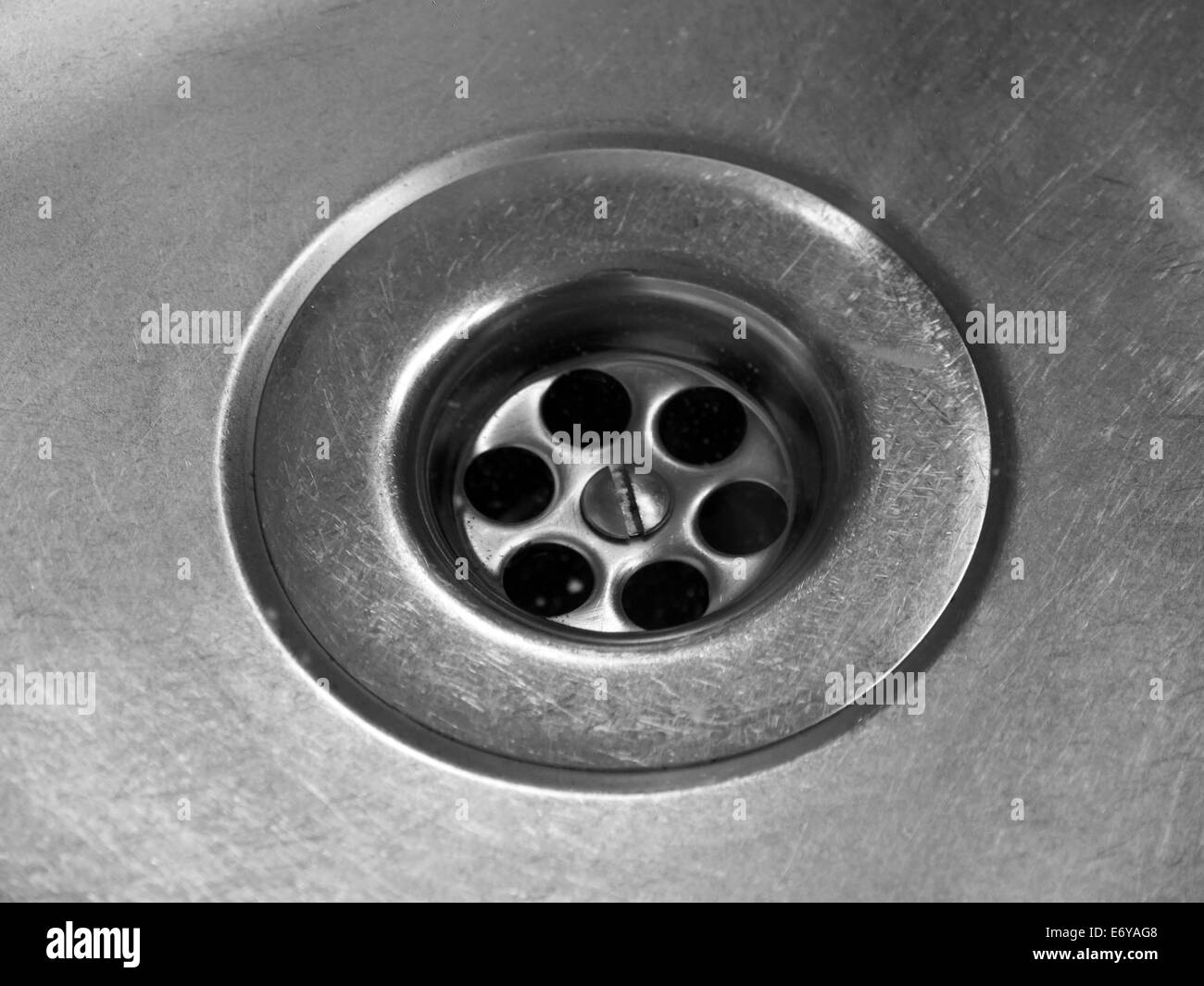 Closeup of drain hole in worn stainless steel kitchen sink Stock Photo