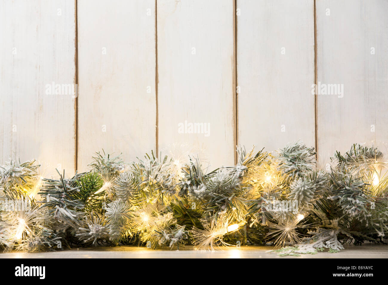 Christmas lights and fir branch on wood plank Stock Photo - Alamy