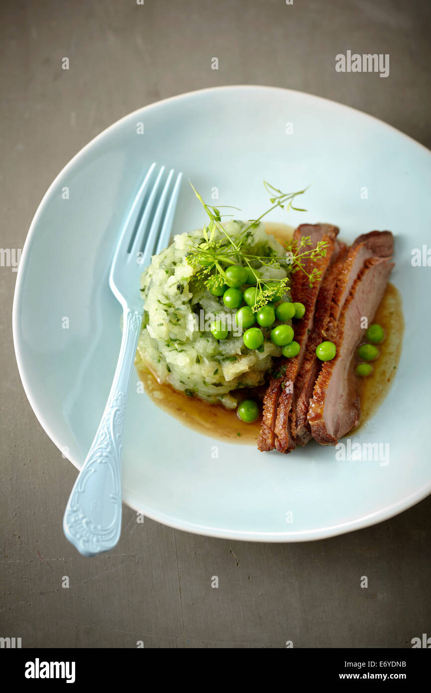 Sliced and roasted duck breast with turnips and peas Stock Photo